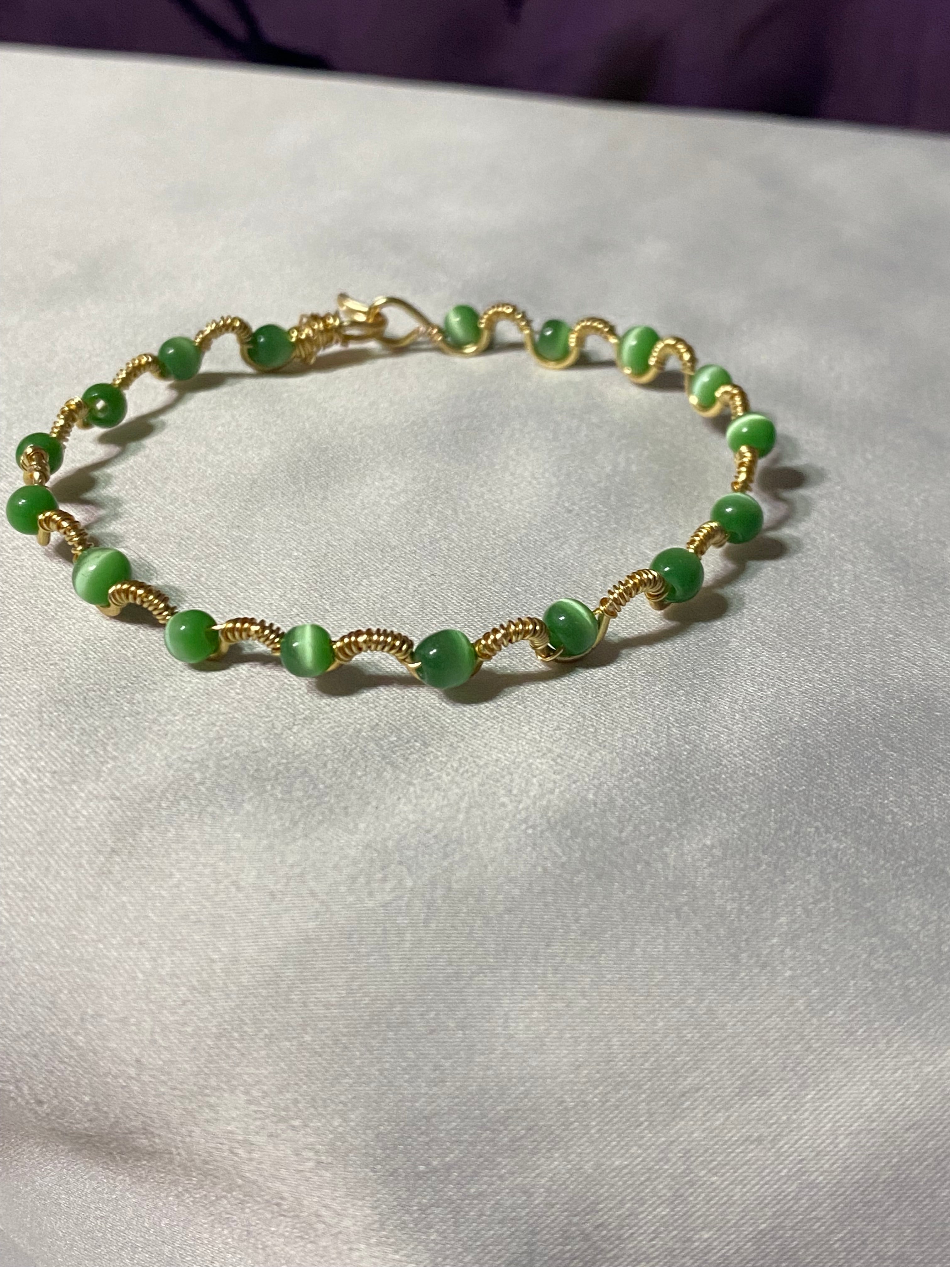 Delicate gold tone bracelet with green beads